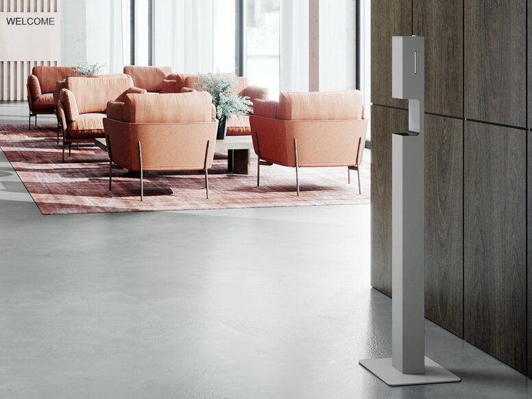 Hotel lobby equipped with disinfectant dispenser and seating in the background